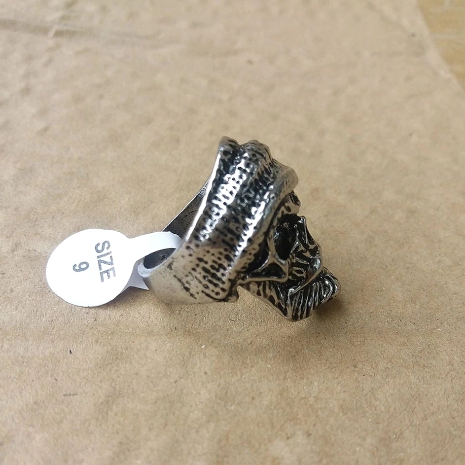 Seitenansicht des Bartschädel-Beanie-Rings mit Größenetikett SIZE 9, zeigt Ringdicke, gestrickte Hutstruktur und die Tiefe des gemeißelten Barthaar-Handwerks in authentischer Silberpatina