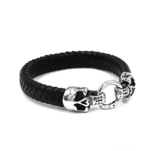 Schwarzes geflochtenes Biker-Lederarmband mit silbernen Totenkopf-Akzenten und rundem Verbindungsring, Seitenansicht mit Verschluss-Detail