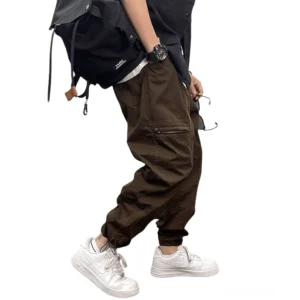 Braune Gothic Cargo Cargohose Seitenansicht auf männlichem Model mit Reißverschluss-Seitentasche und Drop-Crotch-Design, urbaner Streetwear-Stil