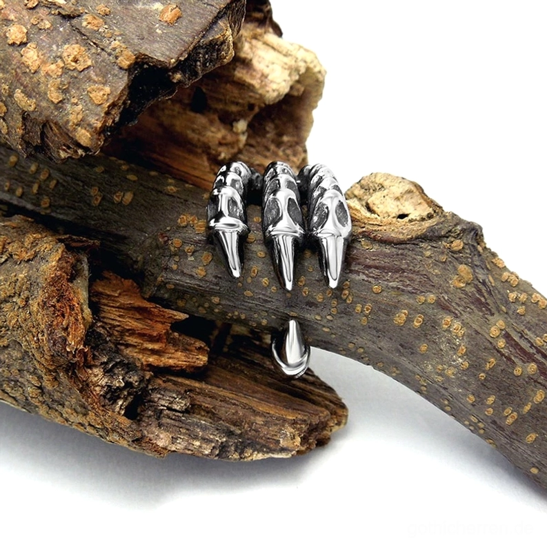 Gothic Drachenkralle Biker Ring auf Holzast platziert zeigt silberne Veredelung vintage Ästhetik und natürliche Patina