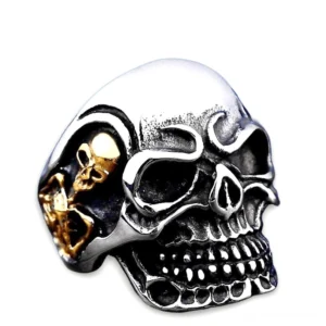 Zweifarbiger Dreifach-Totenkopf-Ring aus Edelstahl mit silberner Basis und goldenen Inlay-Details, gotisches Biker-Design, Draufsicht-Vorderansicht mit Vintage-Finish