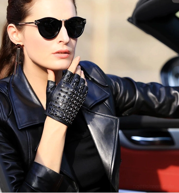 Schwarze Nieten-Fingerlose Lederhandschuhe getragen von Frau mit Sonnenbrille im Cabrio-Auto, Biker-Jacken-Aesthetic, Gothic-Punk-Outdoor-Styling