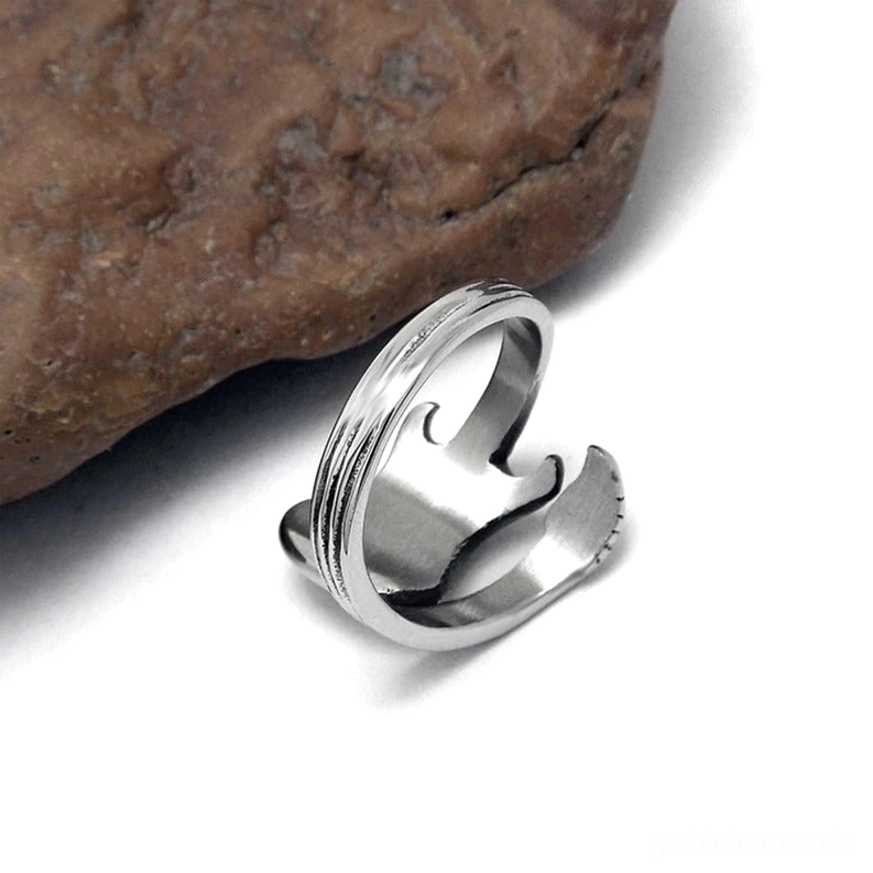 Edelstahl-Gitarren-Ring Unteransicht Rückseite mit poliertem silberner Bandschicht und sichtbarer offener Ring-Struktur auf braunem Steinuntergrund, Schmuck-Detailansicht