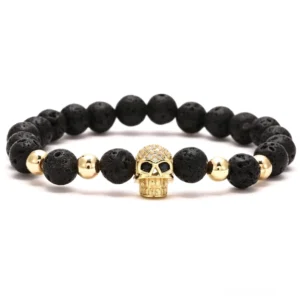 Gold-Totenkopf Kristallbesatz Gothic Armband mit schwarzen 8mm Lavasteinen und goldenen Spacer-Akzenten in Flatlay-Ansicht, minimalistischer gotischer Schmuck mit vulkanischen Steinen