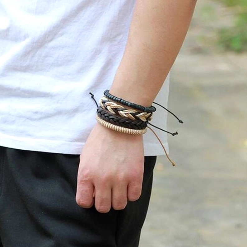 Männliches Modell trägt gestapelten 4-teiligen Gothic Leder Armband Set am Handgelenk, Außenansicht Straßenlook mit Real-World Styling, Alternative Mode Alltag