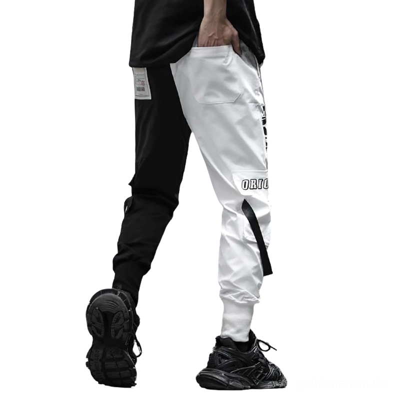 Rückansicht der asymmetrischen Schwarz-Weiß-Patchwork-Cargo-Hose mit Patch-Labeln, webbing Details und gespaltener Farbgestaltung