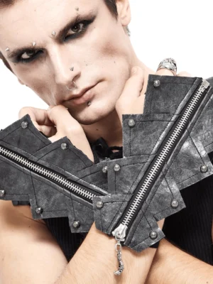 Gothic männliches Model mit schwarzen fingerlose Handschuhe mit Totenschädel-Reißverschluss, dunkles Make-up und Goth-Ästhetik mit Metallnieten-Details im Studio