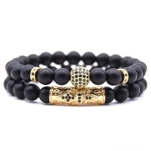 Gothic Dualstrang Perlenarmband mit goldfarbenem Metallfinish, geschnitzter Schließe, durchsichtigen facettierten Kristallakzenten und matten schwarzen Naturstein-Perlen, Produktflatlayansicht vor weißem Hintergrund