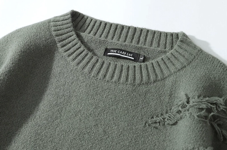 Nahaufnahme gerippter Rundhals-Kragendetail zerrissener Gothic Strickpullover interne Markenmarkierung weiches flauschiges Acryl-Strickgewebe kleine Brustfranse