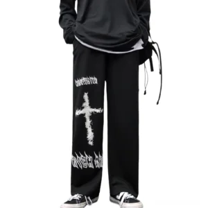 Schwarze Gothic weite Hose mit weißem Graffiti-Kreuz-Print, Vorderansicht auf männlichem Model, vollständige Silhouette zur Anzeige der Schlaghosen-Schnitt und Druckdetails
