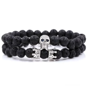 Schwarzes Gun-Black Gothic Totenkopf-Krone Perlenarmband mit vulkanischem Lavastein Schmuck in Flatlayer-Ansicht auf weißem Hintergrund - Dark Alternative Unisex Fashion Statement
