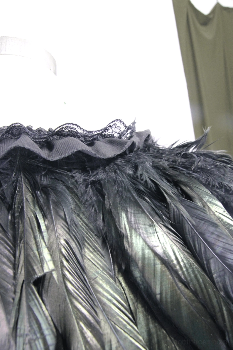 Gothic-Schulterumhang Seite Nahaufnahme Federtextur irisierend schwarze Rabenfeder-Imitation naturalistisches Details optik