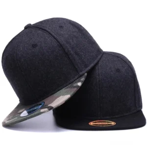 Zwei Gothic Wool Snapback Caps in Schwarz und Camouflage-Variante, schräge Seitenansicht mit flachem Schirm und verstellbarem Verschluss, Studio-Produktfoto