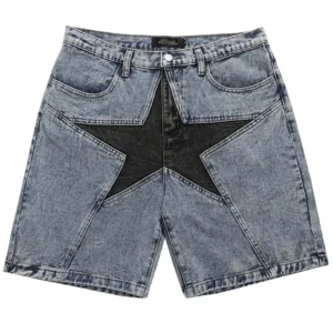 Hellblaue Gothic-Denim-Shorts mit kontrastierenden schwarzen Stern-Patchwork-Panel auf der Vorderseite, Flat-Lay-Ansicht mit Studio-Hintergrund, alternative Herrenmode