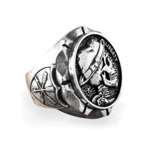 Totenkopf-Siegelring aus Edelstahl in schräger Dreiviertelperspektive mit graviertem Cowboy-Hut-Totenkopf, Liberty 1936 Inschrift und seitlichen Pfeilmustern auf mattem Silber-Finish