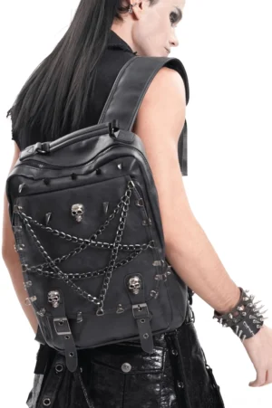 Gotischer Rucksack mit Pentagramm-Kette und Totenkopf-Spikes in schwarz, Rückansicht auf männlichem Goth-Model im Studio mit schwarz-weißem Look und Spike-Armband