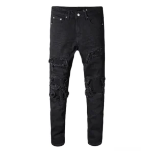 Schwarze Gothic Biker Jeans mit Patchwork-Rissen an Oberschenkeln und Knien, Slim-Fit Pencil-Silhouette, vollständige Länge Vorderansicht auf Flachlage zeigend die destrozierte Denim-Konstruktion