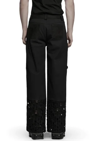 Schwarze Punk-Cargo-Hose Rückansicht von hinten auf Model, zeigt Standard-Taillen-Knopfverschluss und hintere Pattentaschen mit sichtbaren Grommet- und Mesh-Distressing-Details an den Knöcheln