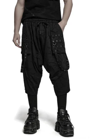 Schwarze Gothic Haremshose mit Ösen-D-Ring-Riemen, Frontansicht am männlichen Modell mit Drop-Crotch-Silhouette und elastischem Bund
