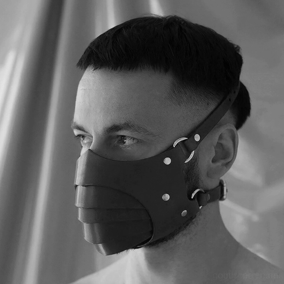 Schwarze Gothic-Ledermaske getragen von kurzharigem männlichem Modell, Winkelansicht von links zeigt Metallniete, geschichtete Lederkonstruktion und Riemen-Details