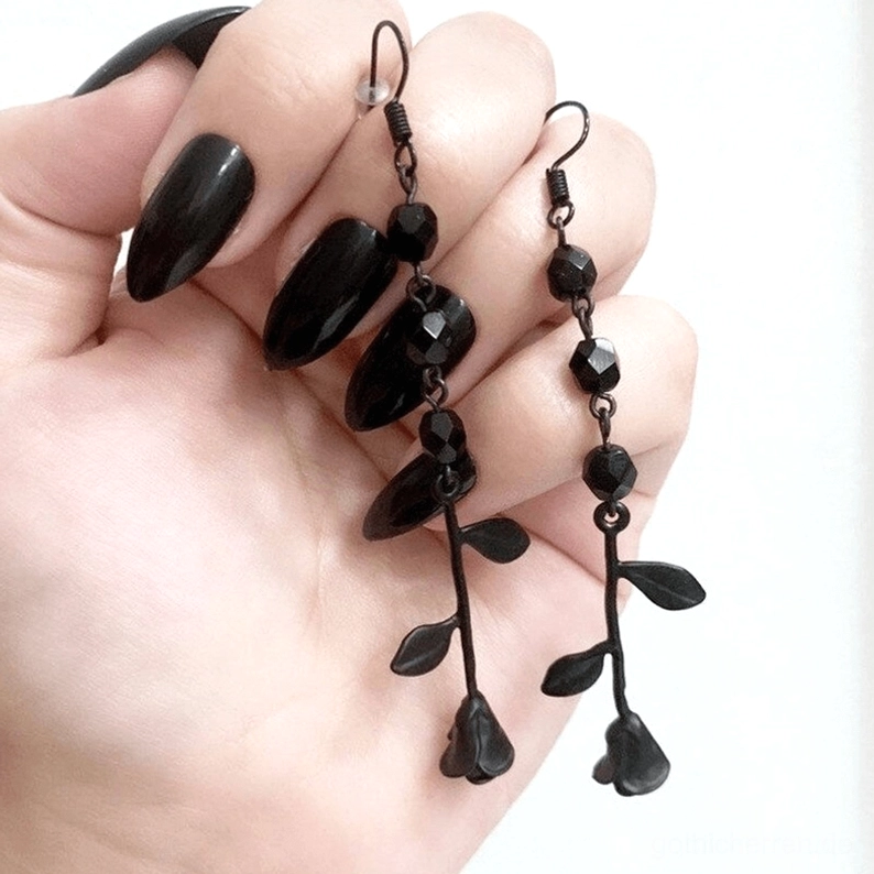 Schwarze Gothic Rose Perlen-Ohrringe mit gemischten facettierten und tropfenförmigen Perlen, Nahaufnahme Detailansicht auf weiblicher Hand mit schwarzem Nagellack