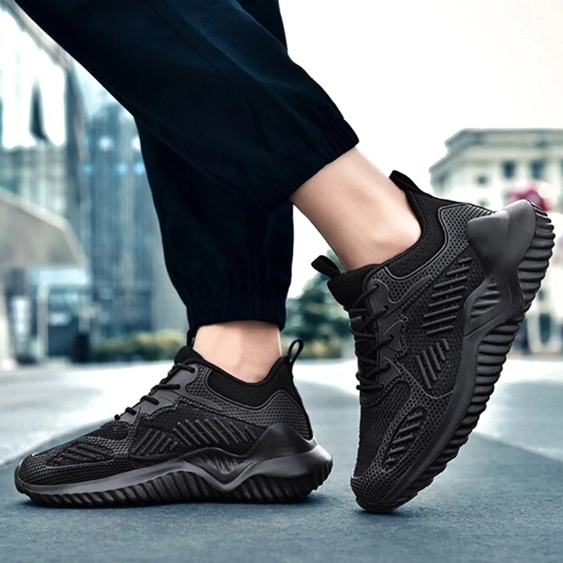 Schwarze Sports Mesh Turnschuhe Street Styling auf Fuß – getragen mit Track Pants, zeigt alternative minimalistische Goth-Kombination