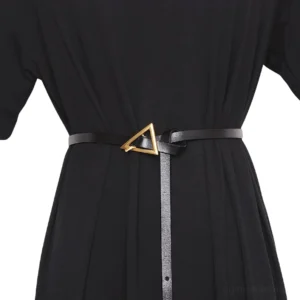 Schwarzer geometrischer Dreieck-Gürtel aus veganem Leder mit goldener Metallschnalle, getragen auf schwarzem Kleid, Frontalansicht mit Schnallen-Detail-Nahaufnahme
