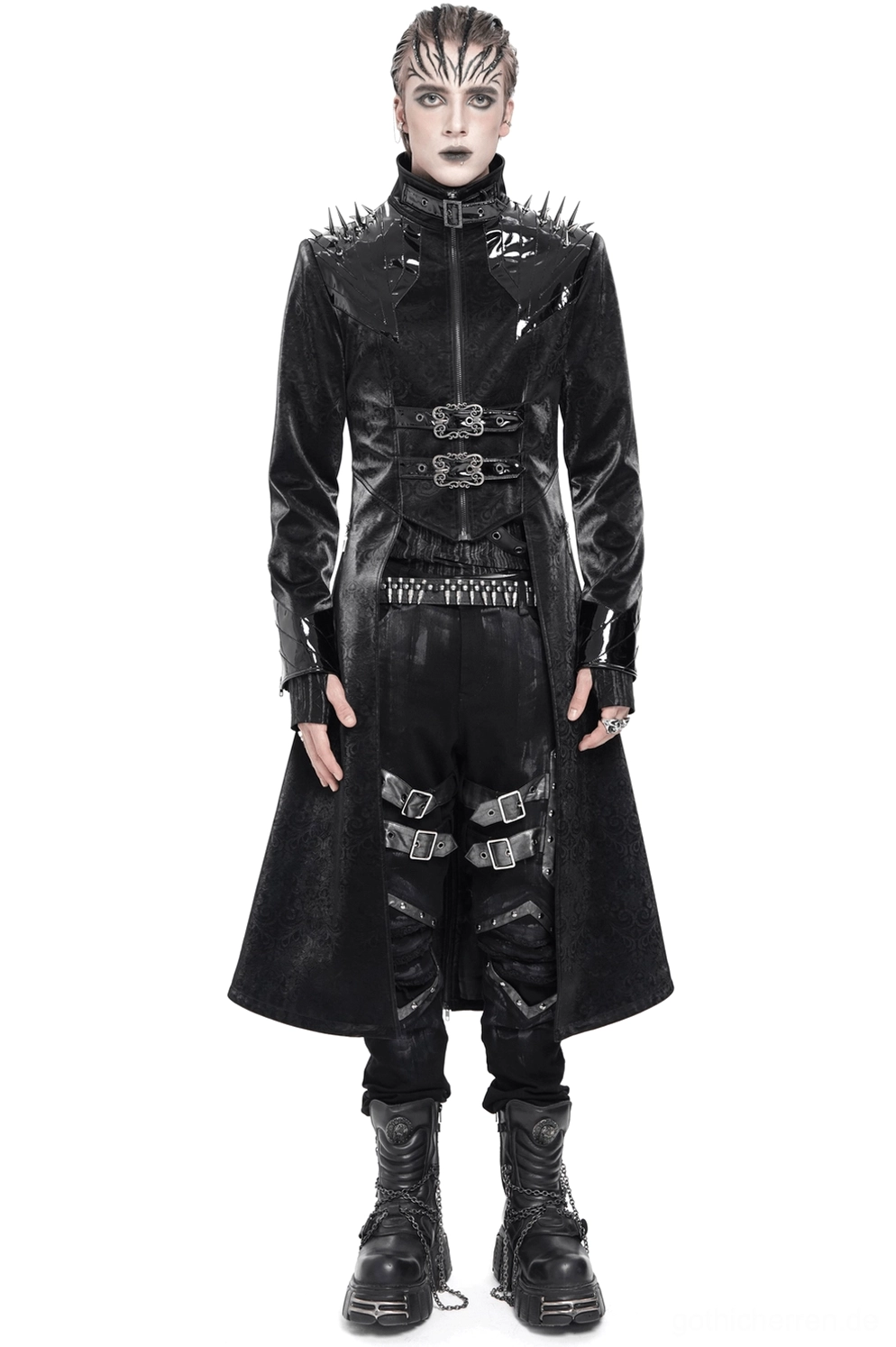 Schwarzer Gothic-Herrenmantel mit Schulterspikes und Metallschnallen, Frontansicht auf Modell in Alternative-Outfit mit Bondage-Hose und Plateaustiefeln