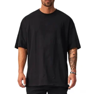 Schwarzes übergroßes Gothic-Crew-Neck-T-Shirt mit Drop-Shoulder-Schnitt auf tätowiertem männlichem Model, Vorderansicht, minimalistische Ästhetik