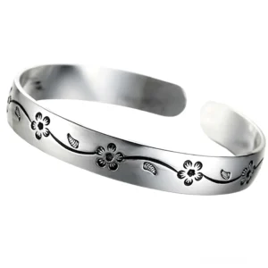 Verstellbares offenes Manschetten-Gotik-Silber-Armband mit polierter Oberfläche und gravierten Blütenmotiven, Frontal-Flachlage-Präsentation